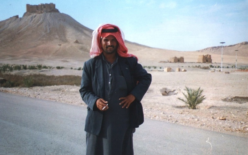 A Bedouin man with Palmyra Castle in the background