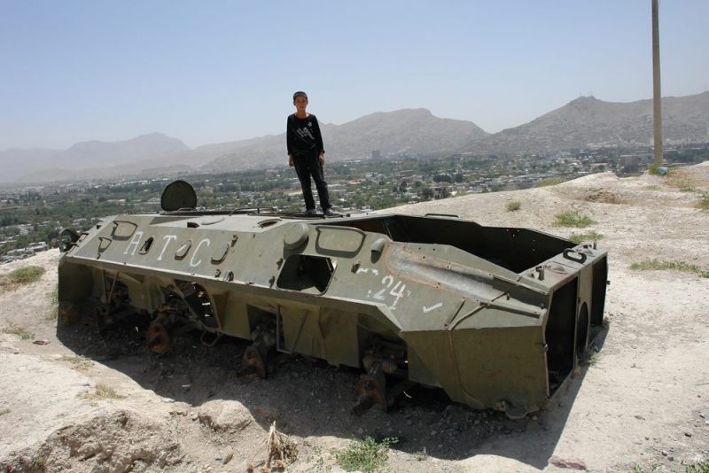 Boy on an abandoned Soviet tank near Kabul, Afghanistan