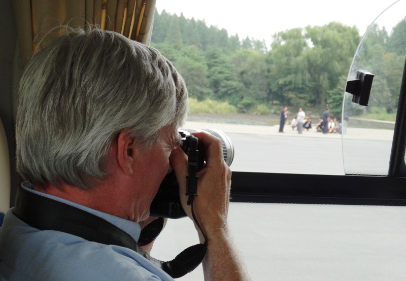 Ray Cunningham taking photos from a tour bus in North Korea
