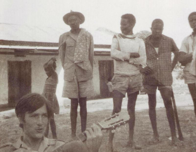 Gordon strums his guitar near the Ugandan border